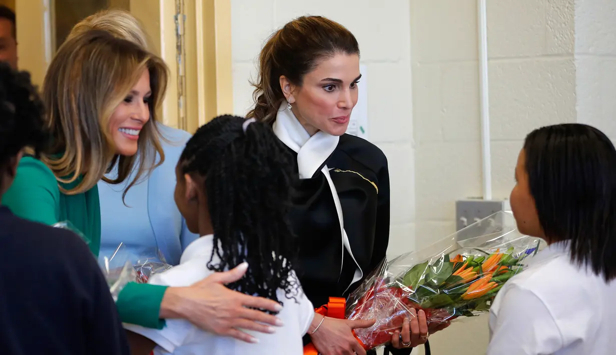 Melania Trump dan Ratu Yordania saat disambut oleh para murid di sekolah Excel Academy Public Charter, Washington, AS (5/4). (AP Photo / Pablo Martinez Monsivais)
