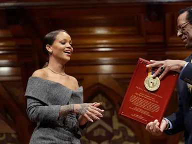 Penyanyi Rihanna (kiri) saat menerima penghargaan dari direktur Harvard Foundation, Allen Counter di Cambridge, AS, (28/2). Rihanna mendapat penghargaan Humanity of the Year Award 2017 dari Harvard University. (AP Photo/Steven Senne)