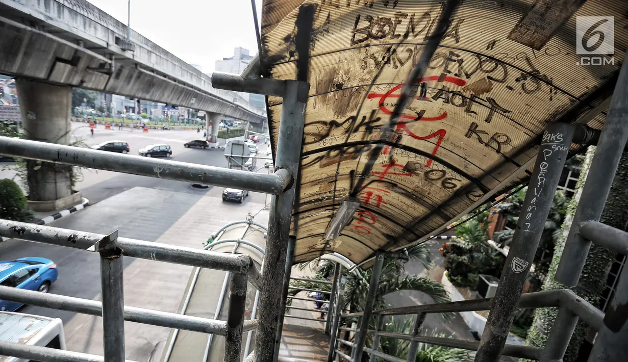 Coret-coretan menghiasi atap Jembatan penyeberangan orang (JPO) di Jalan Iskandarsyah Raya, Blok M, Jakarta, Kamis (23/8). Akibat kondisi JPO yang tidak layak itu banyak pejalan kaki memilih menyeberang di ruas jalan. (Liputan6.com/Faizal Fanani)