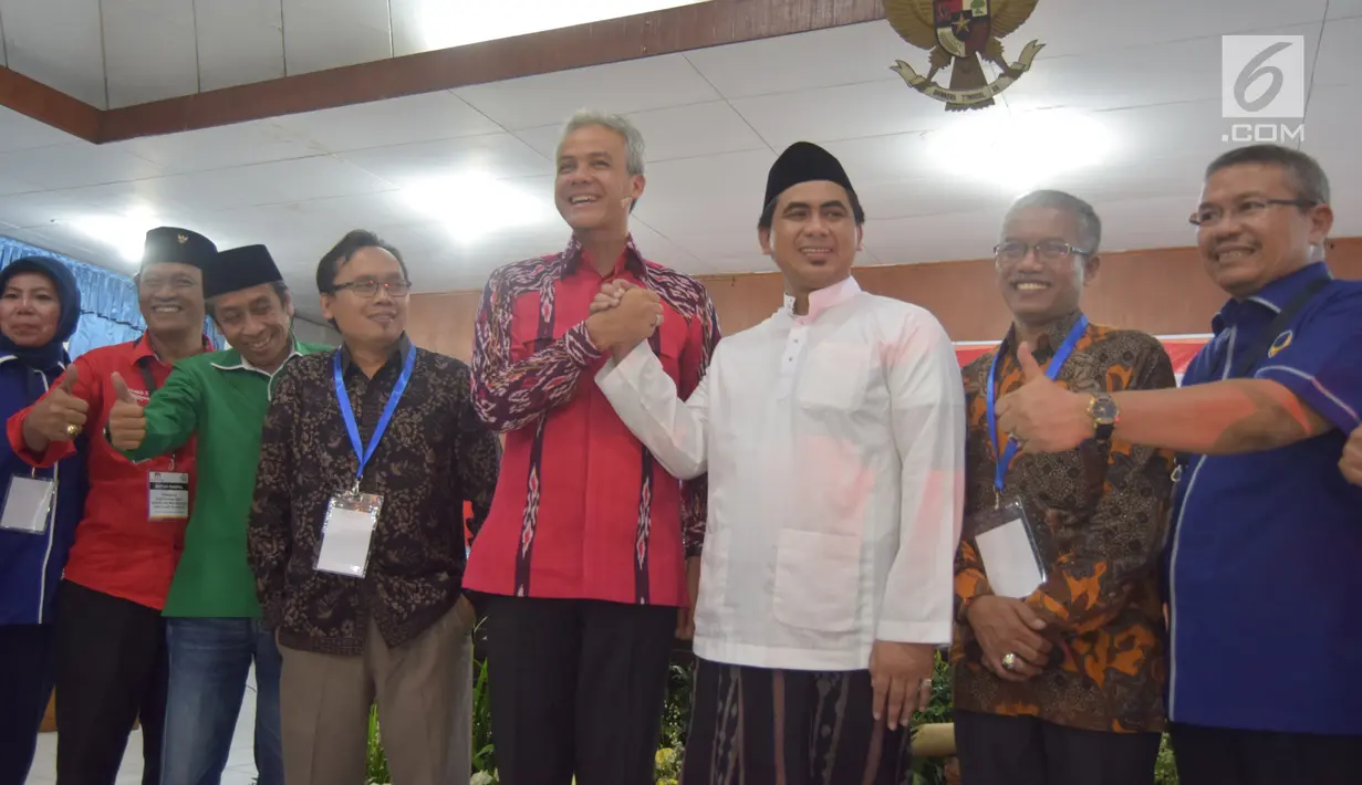 Calon Gubernur Jawa Tengah, Ganjar Pranowo berjabat tangan dengan wakilnya Cawagub Taj Yasin saat mendaftar di KPUD Jateng, Semarang, Selasa (9/1). Pendaftaran paslon ini dilakukan di hari kedua waktu pendaftaran. (Liputan6.com/Gholib)