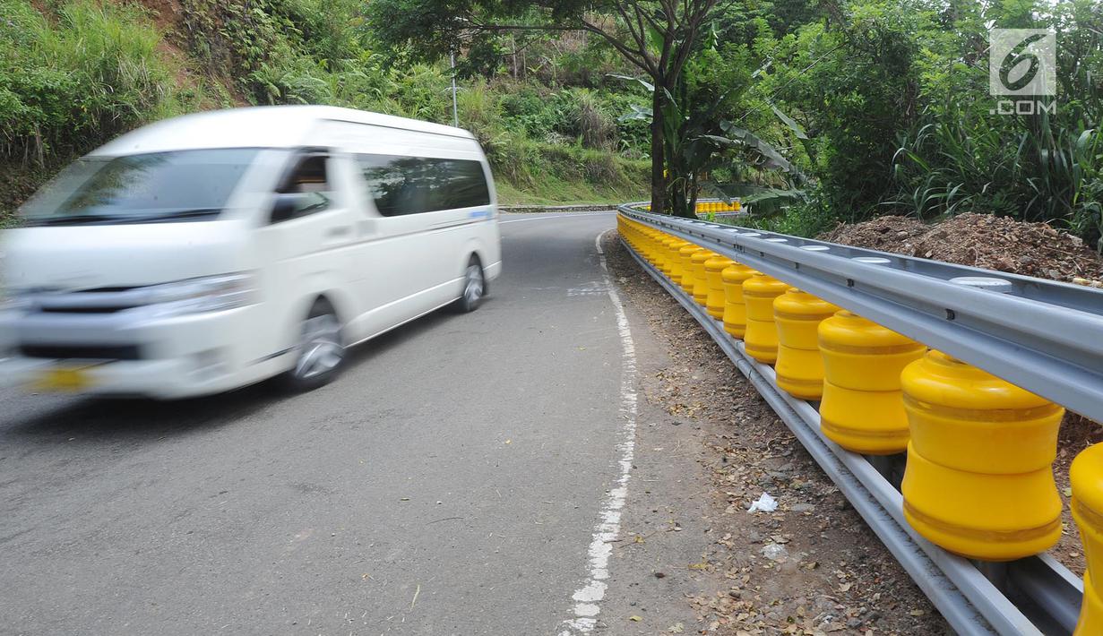 Kendaraan melintas dekat teknologi roller barrier di tanjakan letter S Kampung Bantarselang, Kecamatan Cikidang, Sukabumi, Minggu (6/1). Dibutuhkan sekitar 90 tabung silindir putar untuk roller barrier sepanjang 60 meter ini.  (Merdeka.com/Arie Basuki)