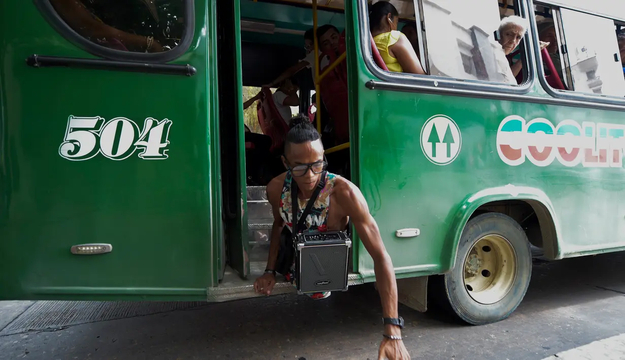 Imigran Venezuela, Alfonso Mendoza alias Alca menuruni bus usai mengamen di Barranquilla, Kolombia, 28 September 2018. Alca mengatasi kesulitan hidup dengan bernyanyi rap dan memberi motivasi pda kaum muda. (Raul ARBOLEDA/AFP)