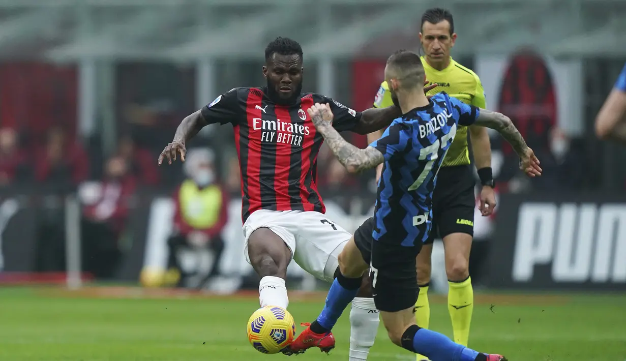 Gelandang AC Milan, Franck Kessie (kiri) berebut bola dengan gelandang Inter Milan, Marcelo Brozovic dalam laga lanjutan Liga Italia 2020/21 pekan ke-23 di San Siro Stadium, Minggu (21/2/2021). AC Milan kalah 0-3 dari Inter Milan. (LaPresse via AP/Spada)