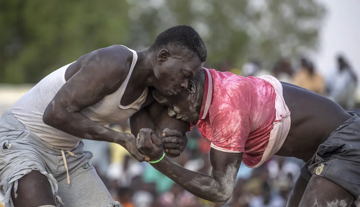Pegulat tim dari daerah Haj Youssef dan Omdurman bersaing dalam kompetisi gulat tradisional Nuba di Ibu Kota Khartoum, Sudan, 30 Juli 2021. (Abdulmonam EASSA/AFP)