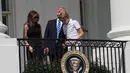 Presiden AS Donald Trump bersama Ibu Negara, Melania Trump dan putra mereka, Barron melihat gerhana matahari dari balkon Gedung Putih di Washington, Senin (21/8). Trump terlihat menyaksikan fenonema langka itu tanpa kacamata pelindung. (NICHOLAS KAMM/AFP)