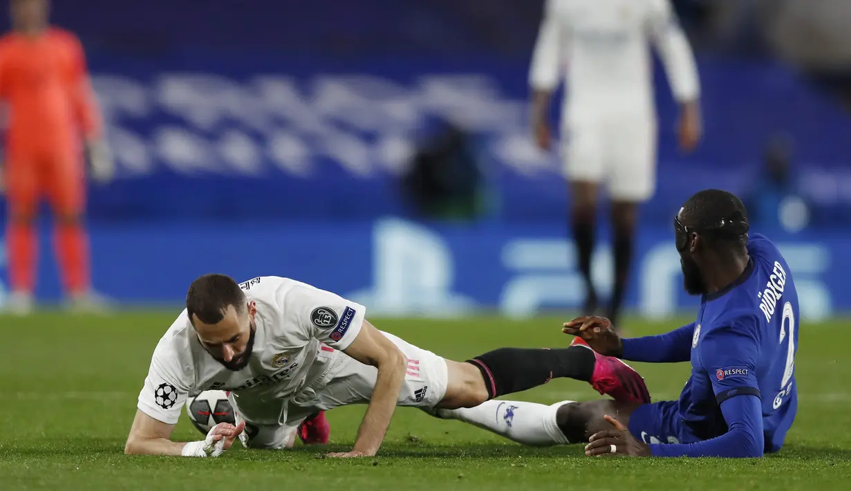 Striker Real Madrid, Karim Benzema (kiri) dan bek Chelsea, Antonio Rudiger terjatuh saat perebutan bola dalam laga leg kedua semifinal Liga Champions 2020/2021 di Stamford Bridge, London, Rabu (5/5/2021). Real Madrid kalah 0-2 dari Chelsea. (AP/Alastair Grant)