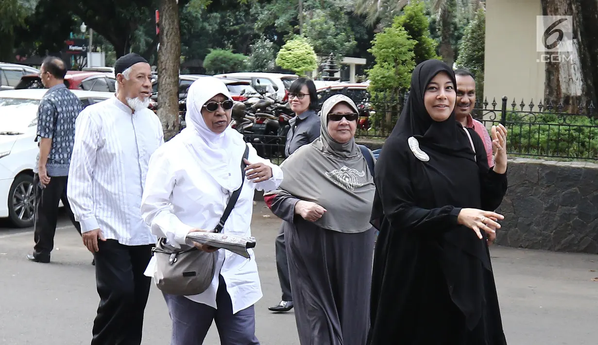 Istri Ustaz Alhabsyi, Putri Aisah Aminah didampingi keluarganya memasuki Gedung Ditreskrimum Polda Metro Jaya, (31/5). Putri menjalani pemeriksaan atas tuduhan perampasan disertai kekerasan terhadap asisten rumah tangganya. (Liputan6.com/Herman Zakharia)