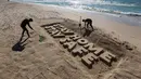 Para seniman Palestina mengukir kata "TETAP DI RUMAH TETAP AMAN" dengan pasir di sebuah pantai di Gaza City pada 12 April 2020. Palestina pada Minggu (12/4) melaporkan jumlah total kasus COVID-19 di negara tersebut telah mencapai 290. (Xinhua/Rizek Abdeljawad)
