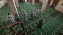 Imam memimpin Umat Muslim, yang mengenakan masker karena pandemi Covid-19, selama salat Idul Fitri di dalam sebuah masjid di desa Shamma, provinsi Nou delta, Menoufia di Mesir pada 24 Mei 2020. (Photo by Mohamed el-Shahed / AFP)