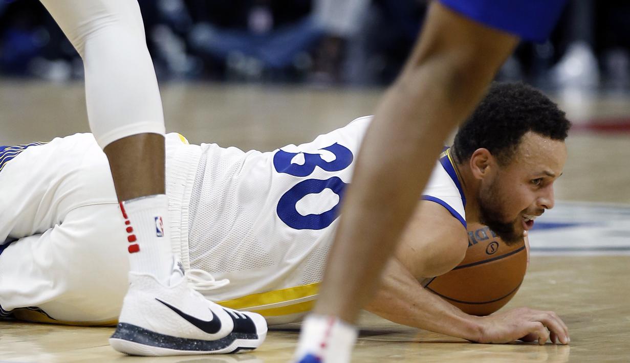 Pemain Golden State Warriors, Stephen Curry (30) jatuh saat berebut bola dengan pemain Los Angeles Clippers pada laga NBA basketball game di Staples Center, Los Angeles, (6/1/2018). Warriors 121-105. (AP/Alex Gallardo)