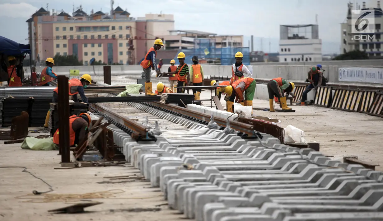 Pemandangan saat pekerja memasang rel di Depo LRT, Kelapa Gading, Jakarta Utara, Kamis (25/1). Pengiriman kereta pertama ke Indonesia dijadwalkan April 2018. (Liputan6.com/Arya Manggala)