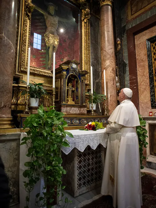 Paus Francis berdoa di St. Marcello al Corso, Roma, Italia, Minggu (15/3/2020). Paus berdoa di depan salib yang pernah dibawa melewati jalan-jalan Roma ketika wabah menimpa kota tersebut pada tahun 1522. (Vatican News via AP)