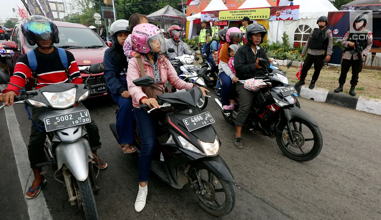 Dua polisi bersenjata laras panjang berjaga di jalur pantura Jalan Jenderal Ahmad Yani, Bypass, Kota Cirebon, Kamis (22/6). Selama arus mudik Lebaran, pasukan bersenjata lengkap diterjunkan guna mengantisipasi gangguan keamanan  (Liputan6.com/Johan Tallo)