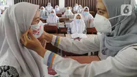 Petugas Sudinkes Jakarta Selatan melakukan kegiatan sosialisasi 3M (memakai masker, mencuci tangan dengan sabun, dan menjaga jarak) kepada para santri di Ponpes Daarul Rahman, Jagakarsa, Rabu (18/11/2020). Sosialisasi 3M tersebut disertai pembagian 3500 masker kain 3 lapis. (merdeka.com/Arie Basuki)