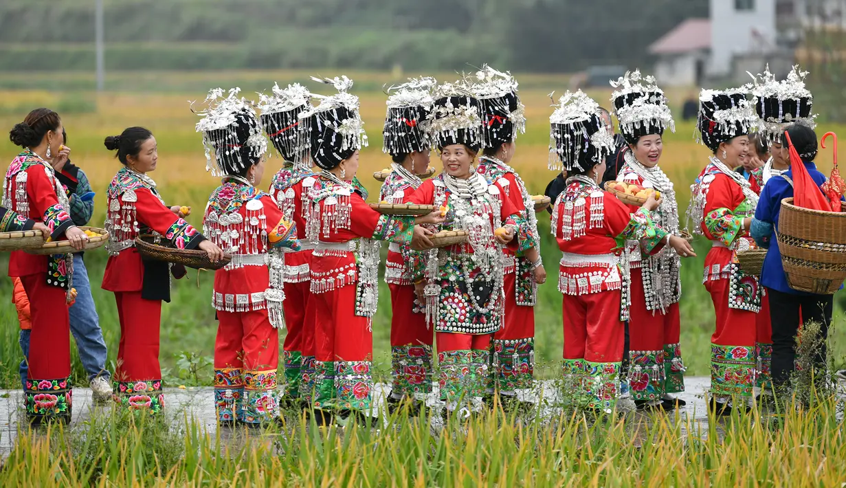 Warga yang mengenakan pakaian tradisional berkeliling untuk memperingati panen raya di Desa Dangzao, Panshi, Kota Tongren, Provinsi Guizhou, China, 20 September 2020. Berbagai aktivitas digelar di seluruh negeri untuk menyambut festival panen petani China ketiga pada 22 September. (Xinhua/Long Enze)