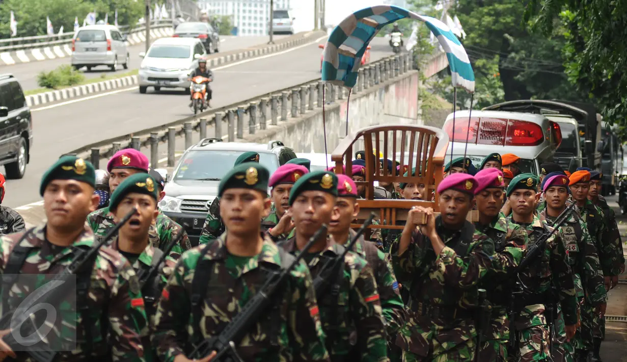 Pasukan gabungan TNI-Polri mengarak replika tandu Jenderal Sudirman melintasi Jl. Gerbang Pemuda Senayan, Jakarta, Jumat (22/1/2016). Puncak peringatan HUT ke 100 Jenderal Sudirman bertepatan final turnamen sepakbola. (Liputan6.com/Helmi Fithriansyah)