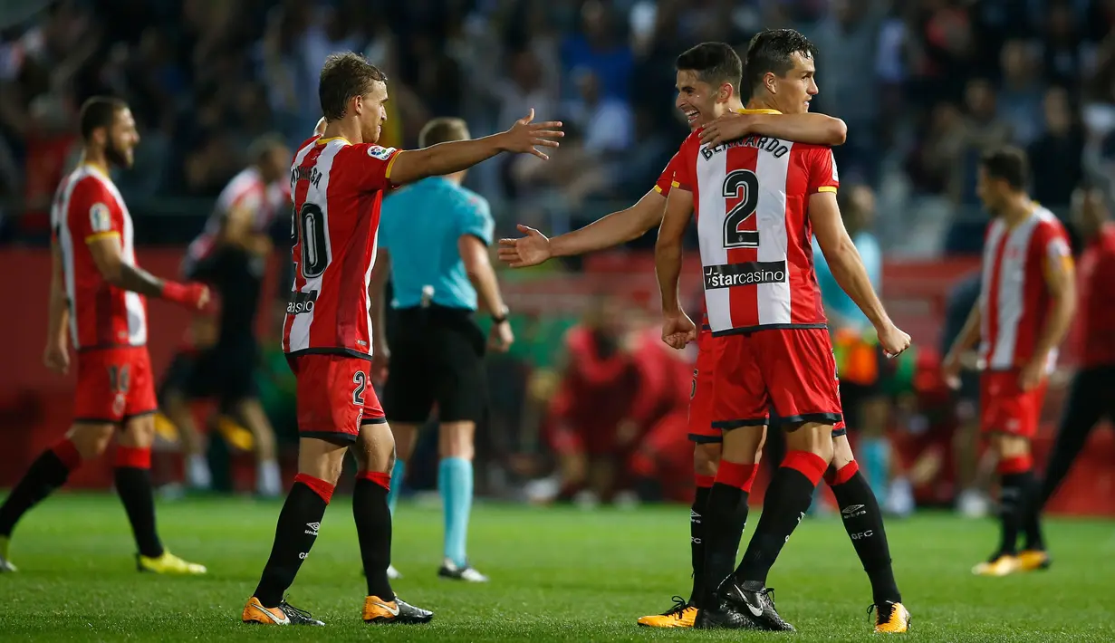 Pemain Girona melakukan selebrasi usai pertandingan melawan Real Madrid dalam pertandingan La Liga di stadion Montilivi di Girona, Spanyol (29/10). Girona berhasil menang dengan skor 2-1 atas Real Madrid. (AP Photo/Manu Fernandez)