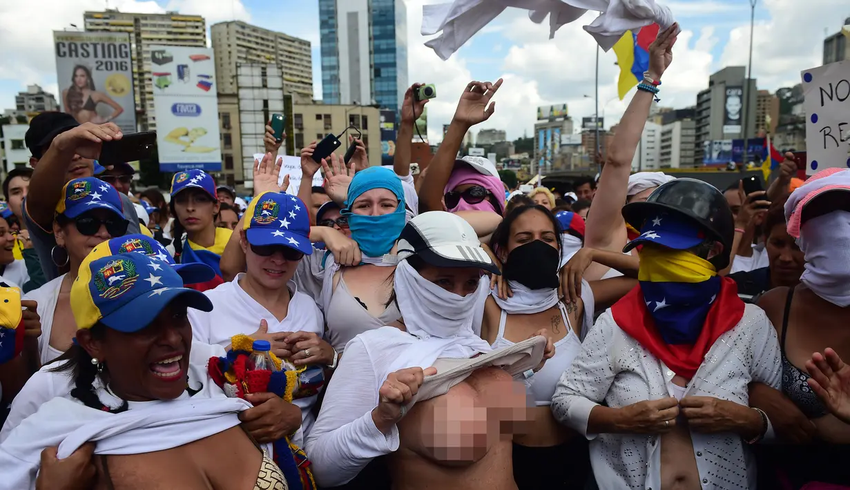 Sejumlah wanita membuka kausnya saat berunjuk rasa menentang Presiden Venezuela Nicolas Maduro di Caracas, Sabtu (6/5). Ratusan wanita berpakaian putih melanjutkan demonstrasi selama lebih dari sebulan untuk menentang Maduro (AFP PHOTO / RONALDO SCHEMIDT)