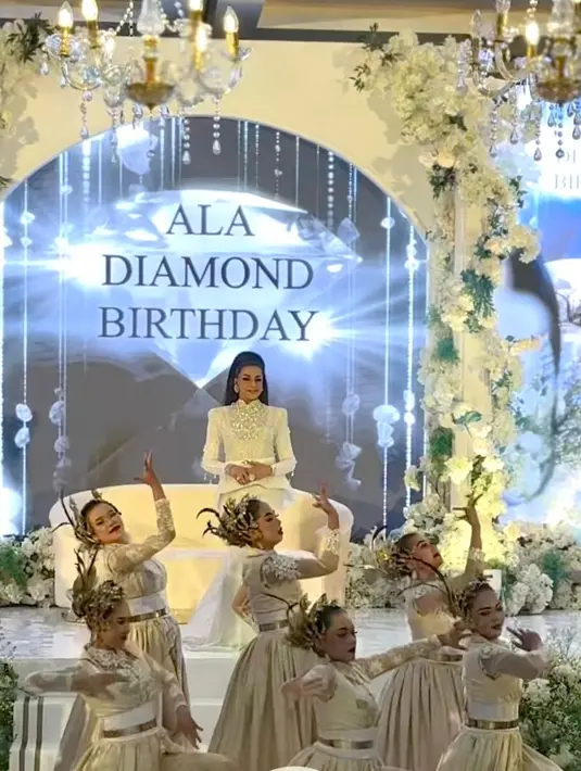 Tampak Ala Alatas yang tampil glamor kenakan dress bersiluet duyung warna putih yang juga selaras dengan dekorasi ulang tahunnya. [@reddot.livestream].
