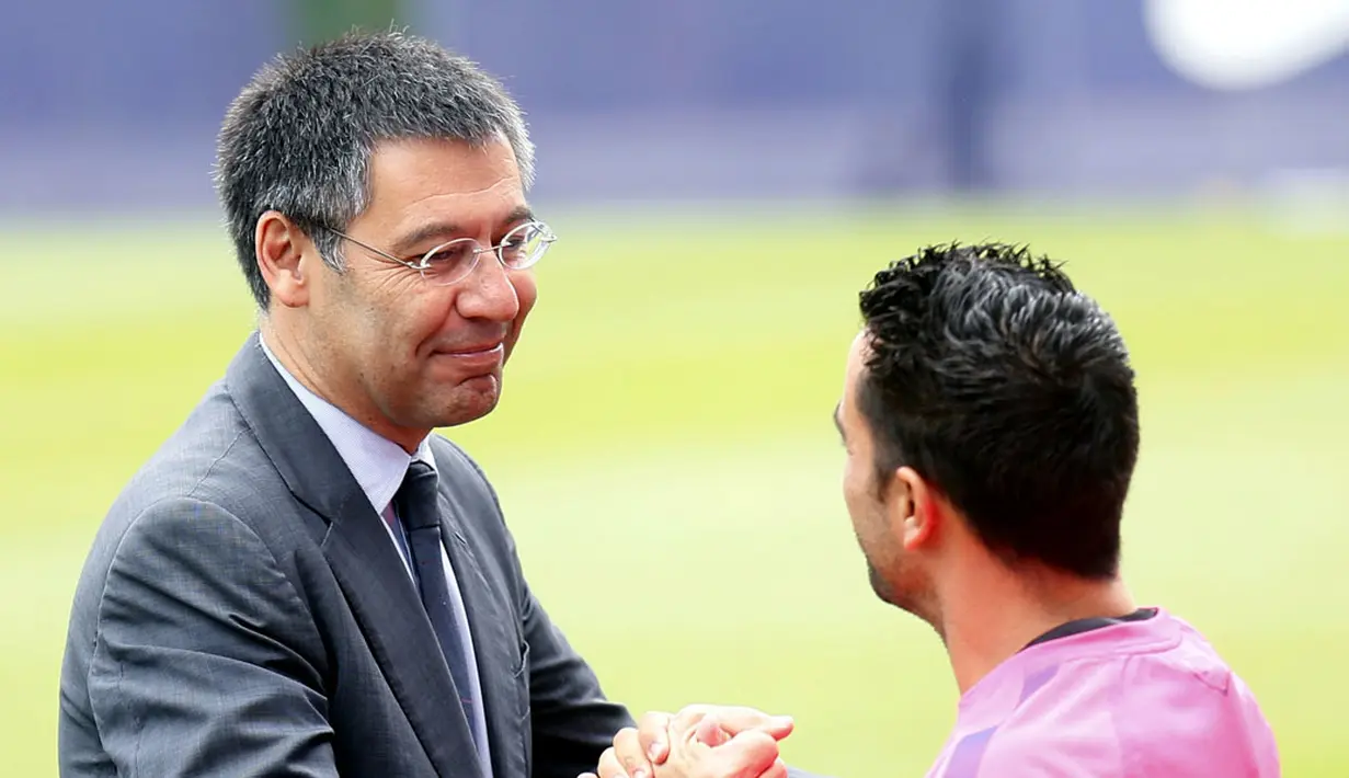 Presiden FC Barcelona, Josep Maria Bartomeu (kiri) menyambut Xavi Hernandez saat sesi latihan di Joan Gamper training camp, (25/7/2014). (REUTERS/Albert Gea)