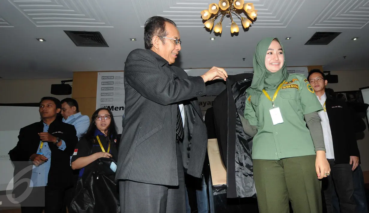 Salah satu Pimpinan KPK, Zulkarnain (kiri) saat memakaikan jaket anti korupsi dalam acara Workshop di gedung KPK, Jakarta, Kamis (12/11/2015). Kpk ingin tanamkan mental pemilih yang berintegritas. (Liputan6.com/Helmi Afandi) 