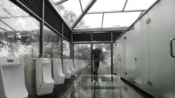 Pengunjung berada di dalam toilet di sebuah taman di Changsha, Tiongkok, Kamis (29/9). Tak hanya dinding yang terbuat dari kaca, lantainya pun juga terbuat dari kaca transparan. (REUTERS/Stringer)