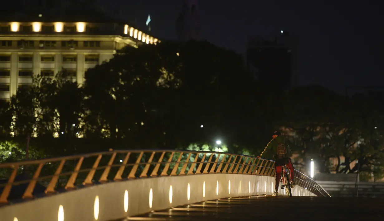 Seorang pria menyeimbangkan sepeda saat melihat keluar dari jembatan saat lockdown di Buenos Aires, Sabtu (22/5/2021). Argentina memberlakukan lockdown COVID-19 pertama kalinya di tahun 2021 mulai Sabtu karena melonjaknya tingkat infeksi dan kematian akibat virus corona. (AP Photo/Mario De Fina)
