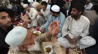 Muslim berdoa sebelum berbuka puasa bersama, selama bulan suci Ramadhan di pinggir jalan, di Islamabad, Pakistan, 5 April 2022. Umat Muslim di seluruh dunia menjalankan Ramadhan, di mana mereka menahan diri dari makan, minum, merokok dan seks dari fajar hingga senja. (AP Photo/Rahmat Gul)