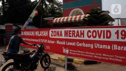 Spanduk zona merah terpasang di depan gerbang utama perumahan Villa Mutiara Cinere, Depok, Jawa Barat, Jumat (16/7/21). Sebanyak 100 orang warga di perumahan Villa Mutiara Cinere terkonfirmasi positif Covid-19. (Liputan6.com/Johan Tallo)