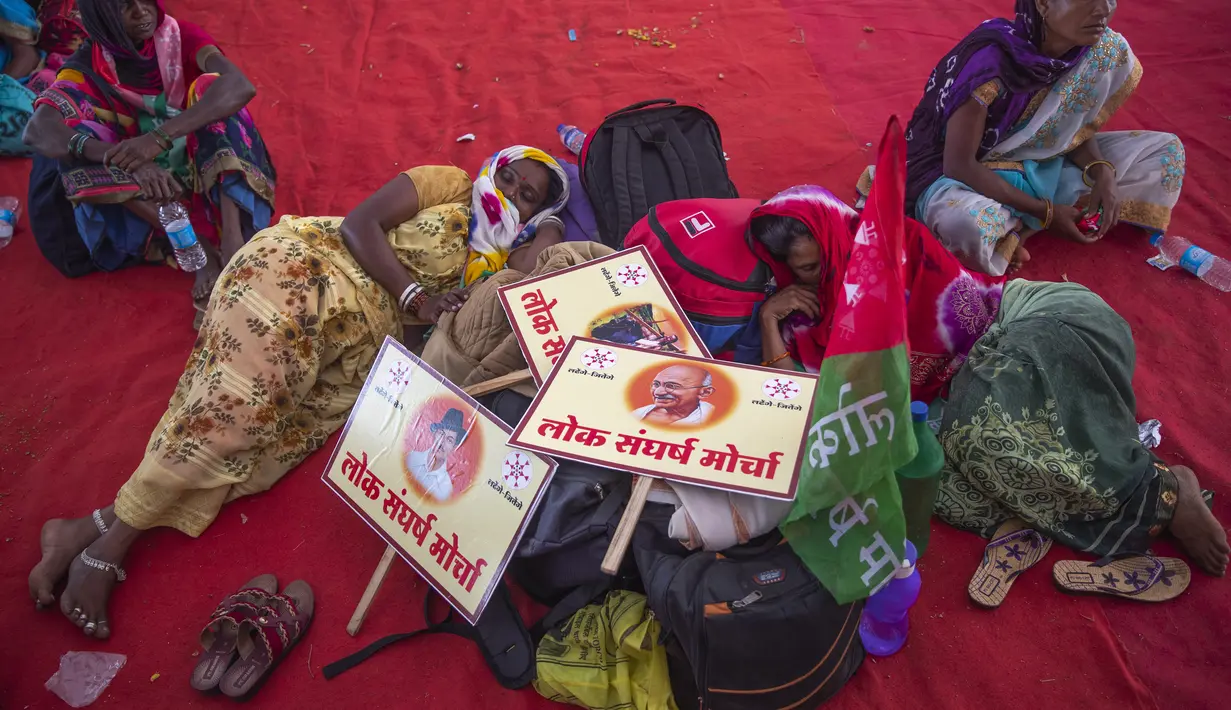 Dua petani perempuan tidur saat berpartisipasi dalam protes solidaritas petani, di Mumbai, India, Minggu (28/11/2021). Kelompok tani menunggu undang-undang pertanian yang kontroversial untuk secara resmi ditarik selama sesi parlemen yang dijadwalkan akan dimulai Senin. (AP Photo/Rafiq Maqbool)