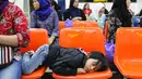 Seorang anak tertidur di kursi bersama keluarganya menunggu verifikasi data TKI dari petugas BP3TKI Serang di Bandara Soekarno Hatta, Tangerang, Sabtu (10/06). (Liputan6.com/Fery Pradolo)