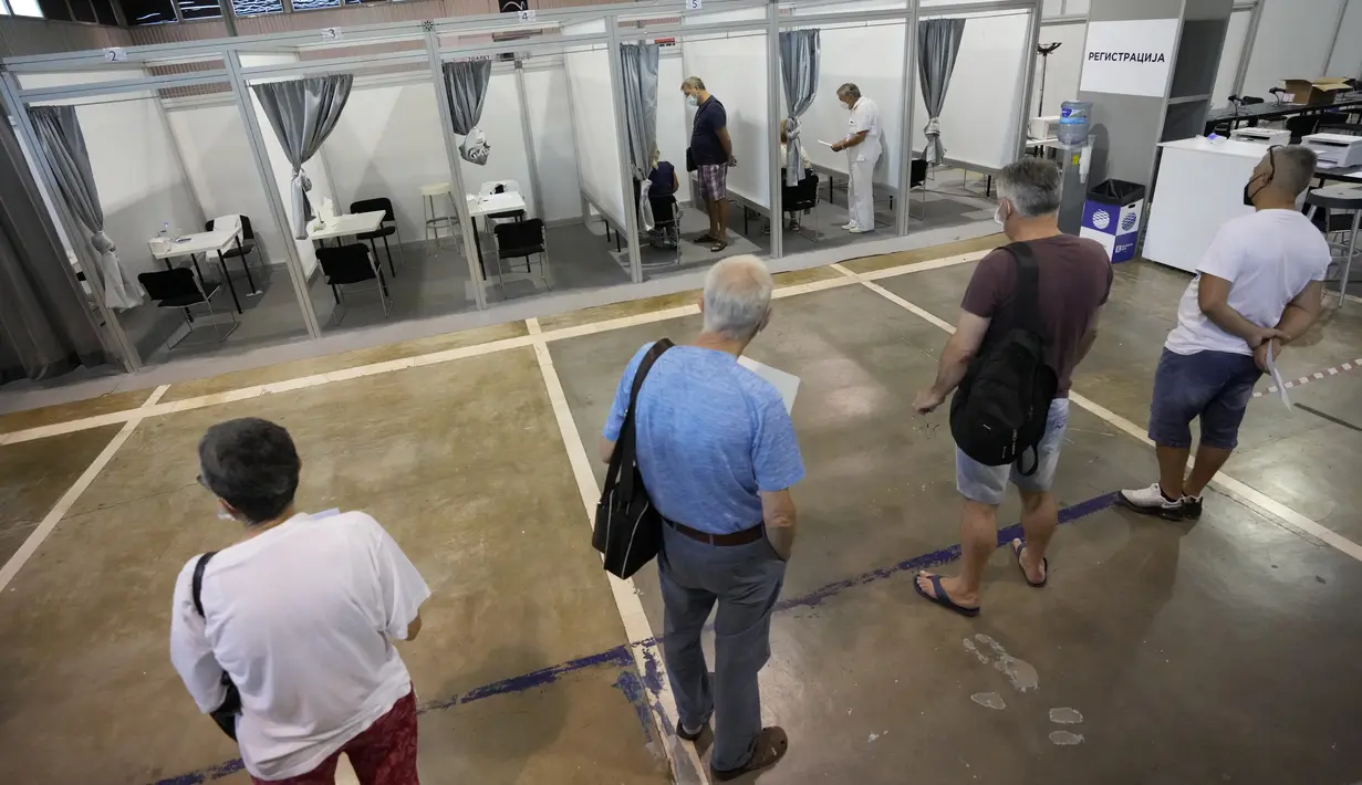 Orang-orang mengantre untuk menerima suntikan vaksin COVID-19 di pusat vaksinasi darurat Belgrade Fair di Belgrade, Selasa (17/8/2021). Serbia mulai memberikan dosis ketiga atau booster, dari empat vaksin berbeda, termasuk Sinopharm, Pfizer, Sputnik dan AstraZeneca. (AP Photo/Darko Vojinovic)