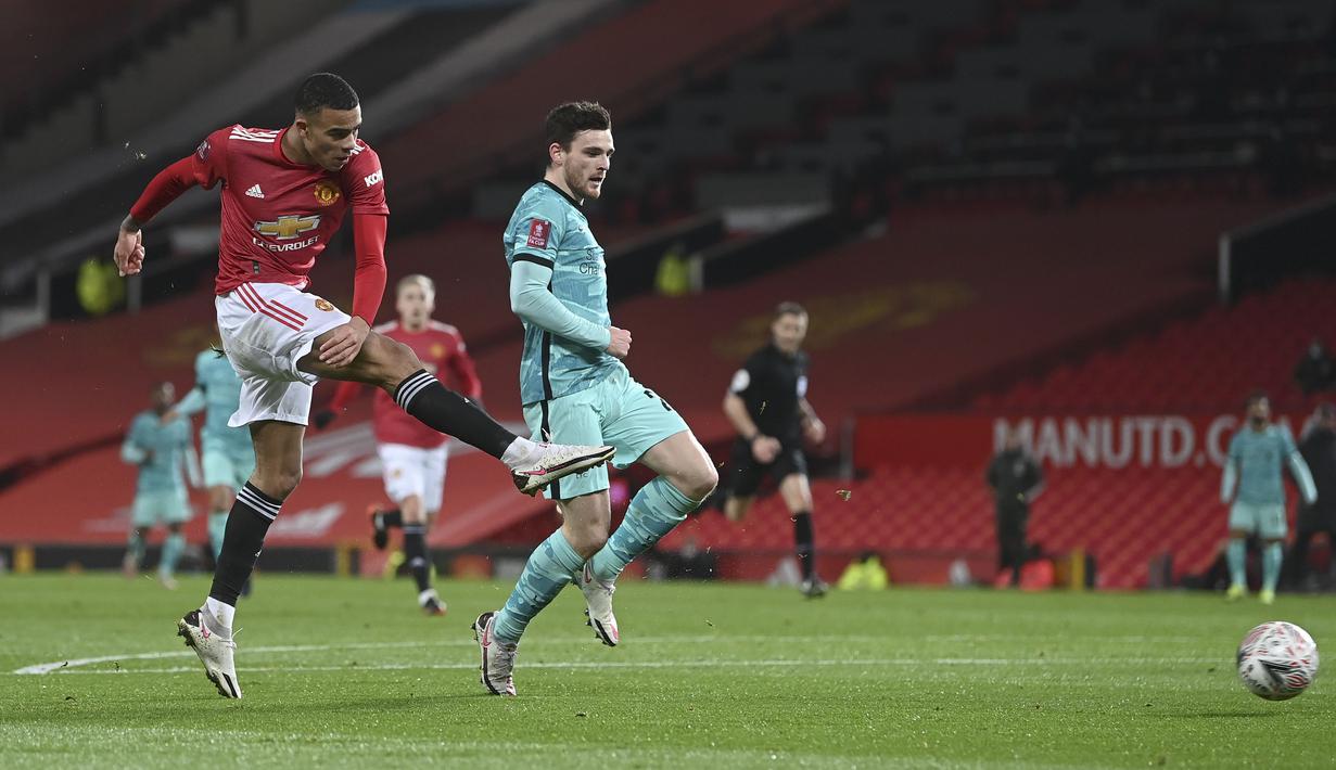 Pemain Manchester United, Mason Greenwood (kiri) melakukan tendangan ke gawang Liverpool pada laga babak keempat FA Cup 2020-21 di Old Trafford, Senin (25/01/2021). (Foto: AP/Pool/Laurence Griffiths)