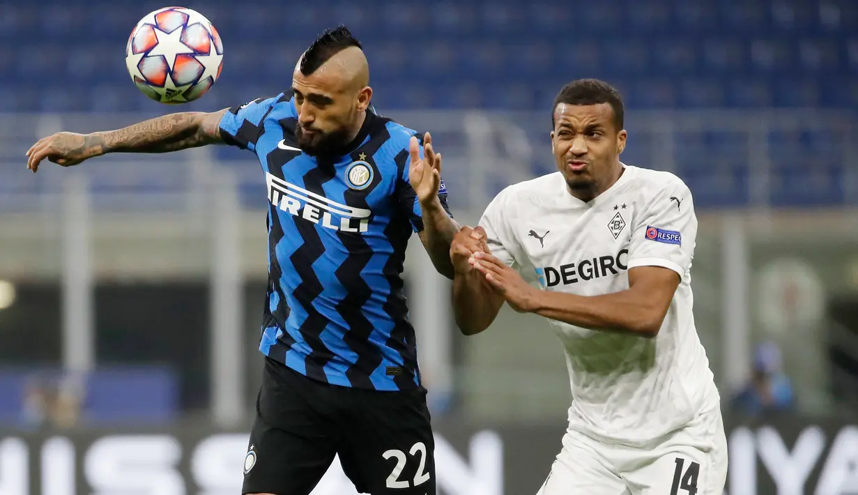 Gelandang Inter Milan, Arturo Vidal berebut bola dengan Alassane Plea dari Borussia Moenchengladbac pada matchday pertama Grup B Liga Champions di Giuseppe Meazza, Kamis (22/10/2020) dini hari WIB. Inter Milan harus puas bermain imbang 2-2 saat menjamu tamunya Monchengladbach. (AP Photo/Luca Bruno)