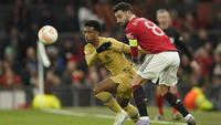 Gelandang Manchester United, Bruno Fernandes berebut bola dengan pemain Barcelona, Alejandro Balde selama pertandingan leg kedua playoff Liga Europa stadion Old Trafford di Manchester, Inggris, Jumat (24/2/2023). Hasil ini membuat MU lolos dengan agregat kemenangan 4-3 atas Barcelona. (AP Photo/Dave Thompson)