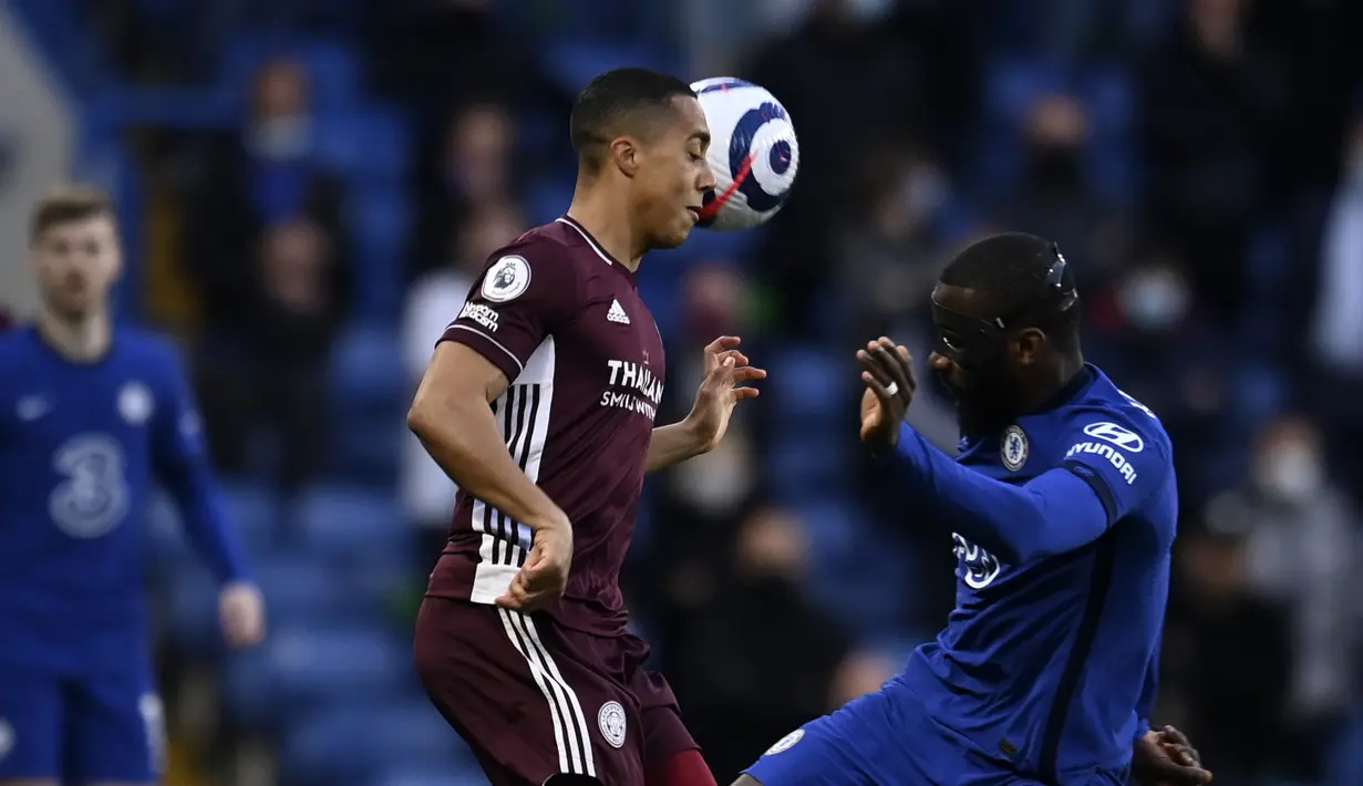 Bek Chelsea, Antonio Rudiger berebut bola dengan gelandang Leicester City, Youri Tielemans dalam laga pekan ke-37 Liga Inggris di Stamford Bridge, London, Rabu (19/5/2021) dinihari WIB. Chelsea menang 2-1 saat menjamu Leicester City. (Glyn Kirk/Pool via AP)