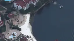 Helikopter melakukan pencarian di atas Walt Disney World Resort, Orlando, Rabu (15/6). Ayah sang bocah melihat buaya yang memiliki panjang 120-213 cm itu menerkam anaknya dan menyeretnya ke dalam danau. (Joe RAEDLE/GETTY IMAGES NORTH AMERICA/AFP)