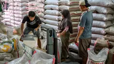 Para pekerja menyiapkan pesanan pelanggan di pasar beras utama di Jakarta pada Rabu 9 Juli 2025. (BAY ISMOYO/AFP)