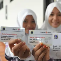 Siswi menunjukan KJP usai menerimanya di SMK 56 Pluit, Jakarta (21/5/2015). Pemprov DKI Jakarta bekerjasama dengan Bank DKI memberikan pelayanan dengan metode transaksi elektronik atau non-tunai untuk pencairan dana KJP. (Liputan6.com/Herman Zakharia)