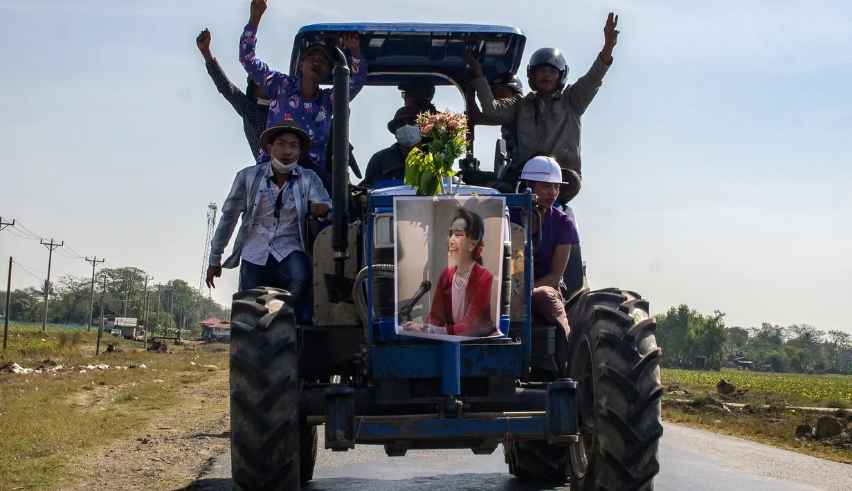 Para petani mengendarai traktor membawa poster pemimpin sipil Myanmar Aung San Suu Kyi yang ditahan saat demonstrasi menentang kudeta militer di Thongwa, di Yangon (12/2/2021). Demonstran yang berlangsung di Myanmar sendiri membuat hampir seluruh pekerja di berbagai perusahaan mogok kerja. (AFP/STR)