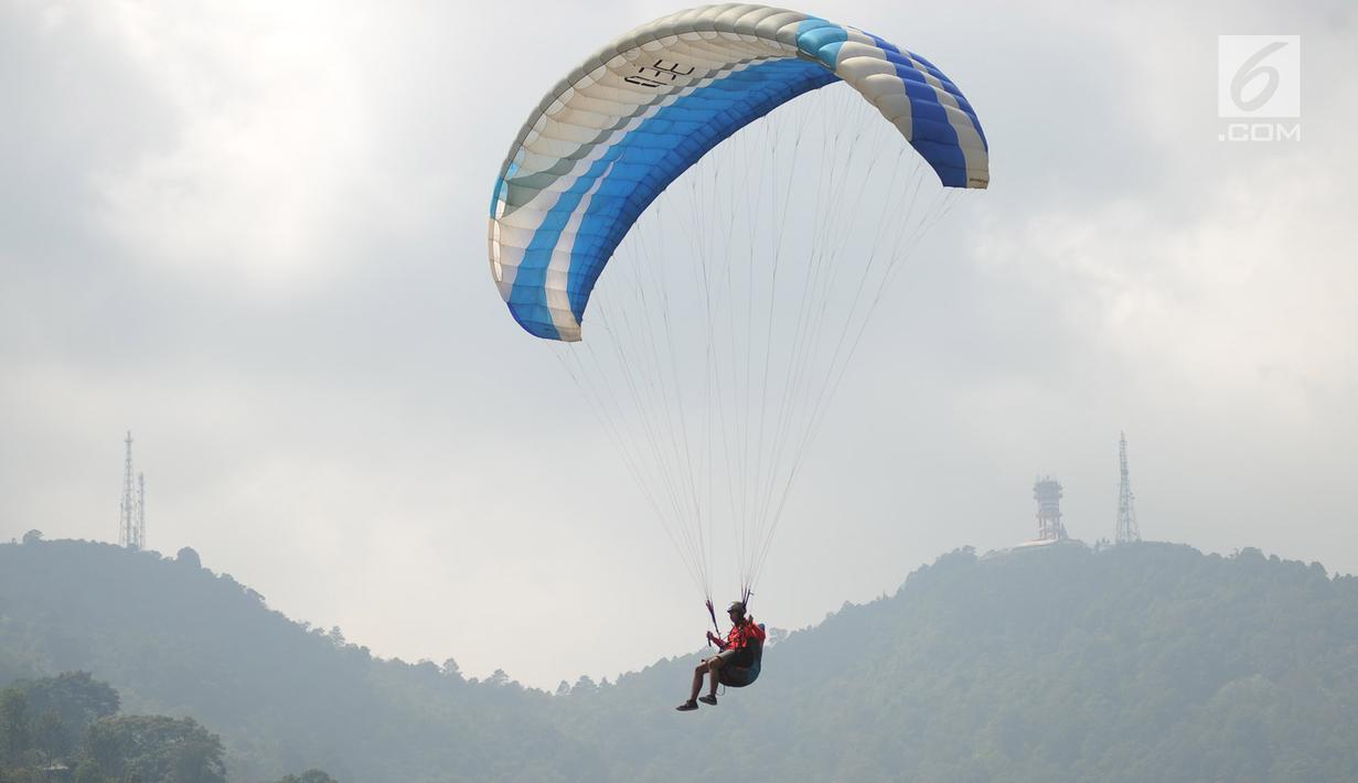 Atlet paralayang Indonesia, Jafro Megawanto saat lepas landas pada babak nomor ketepatan mendarat pria cabang Paralayang Asian Games 2018 di Gunung Mas, Puncak, Jawa Barat, Kamis (23/8). Jafro sukses meraih medali emas. (Merdeka.com/Arie Basuki)