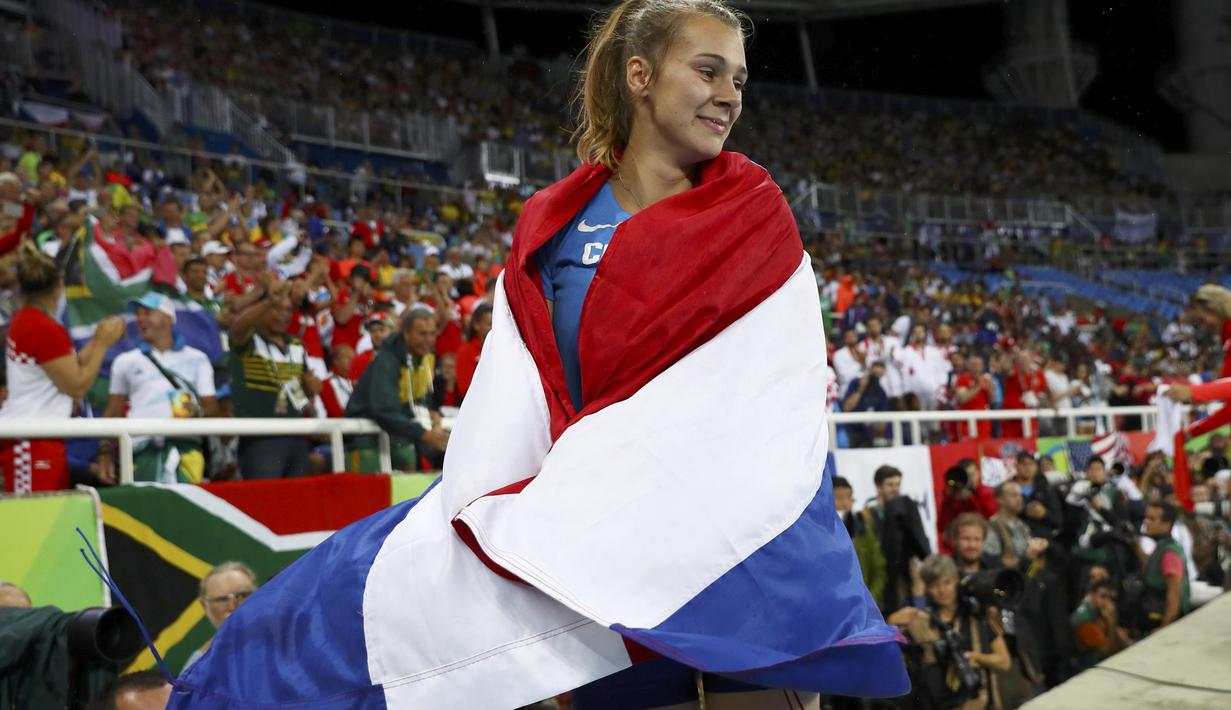 Sara Kolak berselimut bendera Kroasia usai meraih medali emas pada nomor lempar lembing putri Olimpiiade Rio 2016 di Stadion Olimpic, Rio de Janeiro (19/8/2016). (Reuters/Kai Pfaffenbach)