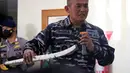 Perwira TNI Angkatan Laut memperlihatkan bagian dari sistem torpedo yang ditemukan dalam operasi pencarian kapal selam KRI Nanggala 402 di Pangkalan Udara Militer Ngurah Rai, Bali, Sabtu (24/4/2021). KRI Nanggala 402 dinyatakan tenggelam atau subsunk. (HANDOUT/INDONESIAN MILITARY/AFP)