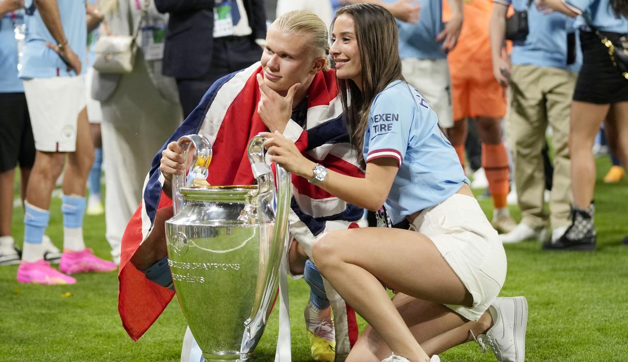 Pemain Manchester City, Erling Haaland, berpose bersama kekasihnya Isabel Haugseng Johansen saat perayaan gelar juara Liga CHampions di Ataturk Olympic Stadium, Istanbul, Minggu (11/6/2023). Erling Haaland tampil luar biasa dan mampu meraih treble winner di musim perdananya bersama City. (AP Photo/Francisco Seco)