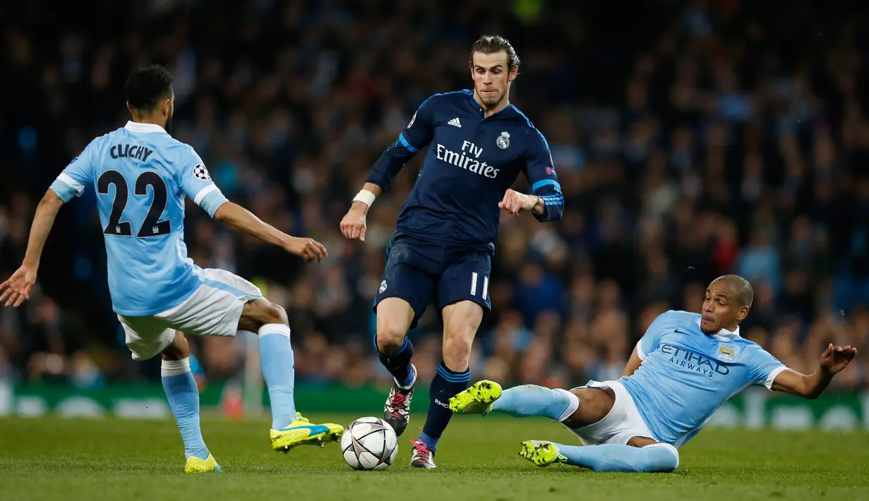 Gelandang Real Madrid, Gareth Bale (tengah) berusaha melewati dua pemain Manchester City pada leg pertama Semifinal Liga Champions di stadion Etihad, Inggris, (27/4). Real Madrid menahan imbang tuan rumah City dengan skor 0-0. (Reuters/Phil Noble)