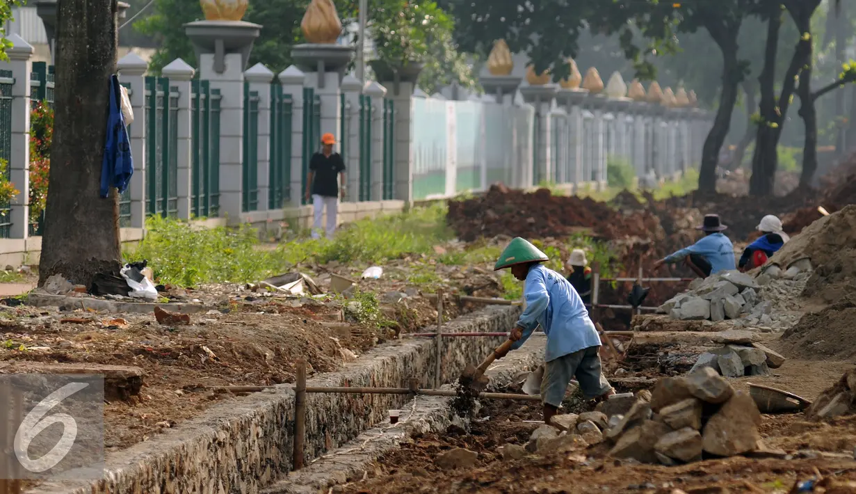 Pekerja merapikan pembuatan saluran air di sekitar trotoar Jalan Gerbang Pemuda Senayan, Jakarta, Kamis (25/8). Pembenahan trotoar di Jalan Gerbang Pemuda dan Asia Afrika, ditargetkan selesai pada akhir 2017. (Liputan6.com/Helmi Fithriansyah)