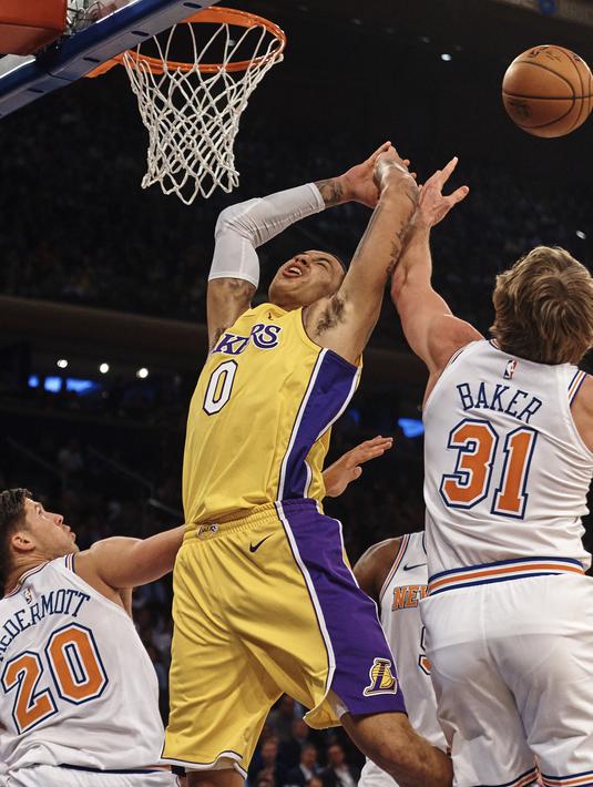 Pemain Los Angeles Lakers, Kyle Kuzma (tengah) gagal mencetak poin setelah diadang pemain New York Knicks, Ron Baker (31) pada lanjutan NBA basketball game di Madison Square Garden, New York, (12/12/2017). knicks menang 113-109. (AP/Andres Kudacki)