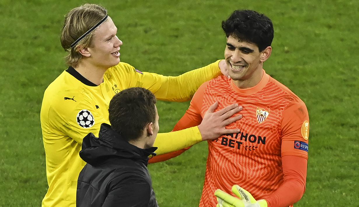 Namun setelah laga usai suasana menjadi cair. Erling Haaland tampak meminta maaf dan bercanda dengan kiper Sevilla, Yassine Bounou. (Photo by Ina Fassbender / various sources / AFP)