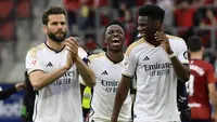 Pemain Real Madrid, Vinicius Junior, Nacho dan Aurelien Tchouameni merayakan kemenangan atas Osasuna pada laga pekan ke-29 La Liga 2023/2024 di Stadion El Sadar, Sabtu (16/03/2024). (AP Photo/Alvaro Barrientos)