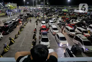 Seorang anak memperhatikan antrean mobil yang akan masuk ke dalam kapal penyeberangan di Pelabuhan Merak, Kota Cilegon, Banten, Jumat (28/3/2025) dini hari. (Liputan6.com/Herman Zakharia)